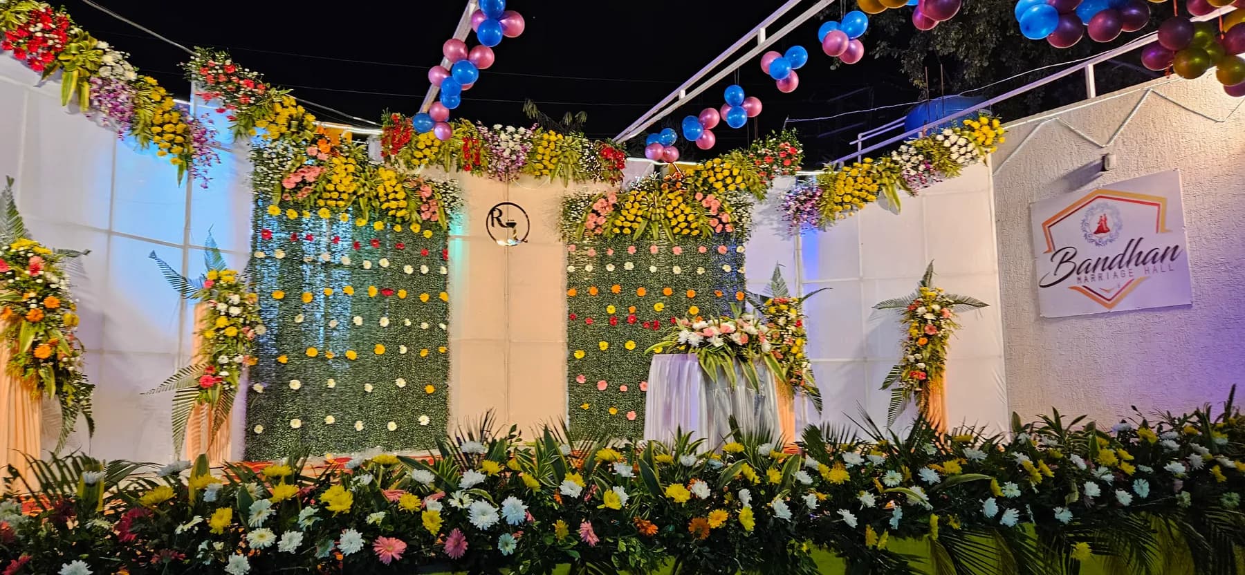 Floral stage backdrop with balloons and Bandhan sign