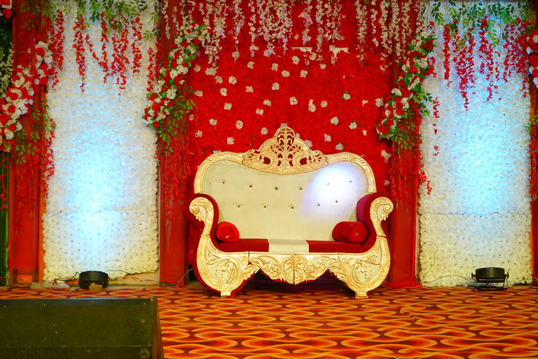 Wedding stage with throne and red floral backdrop